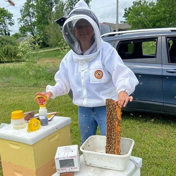 Dr. Tammy Horn Potter tending to beehive